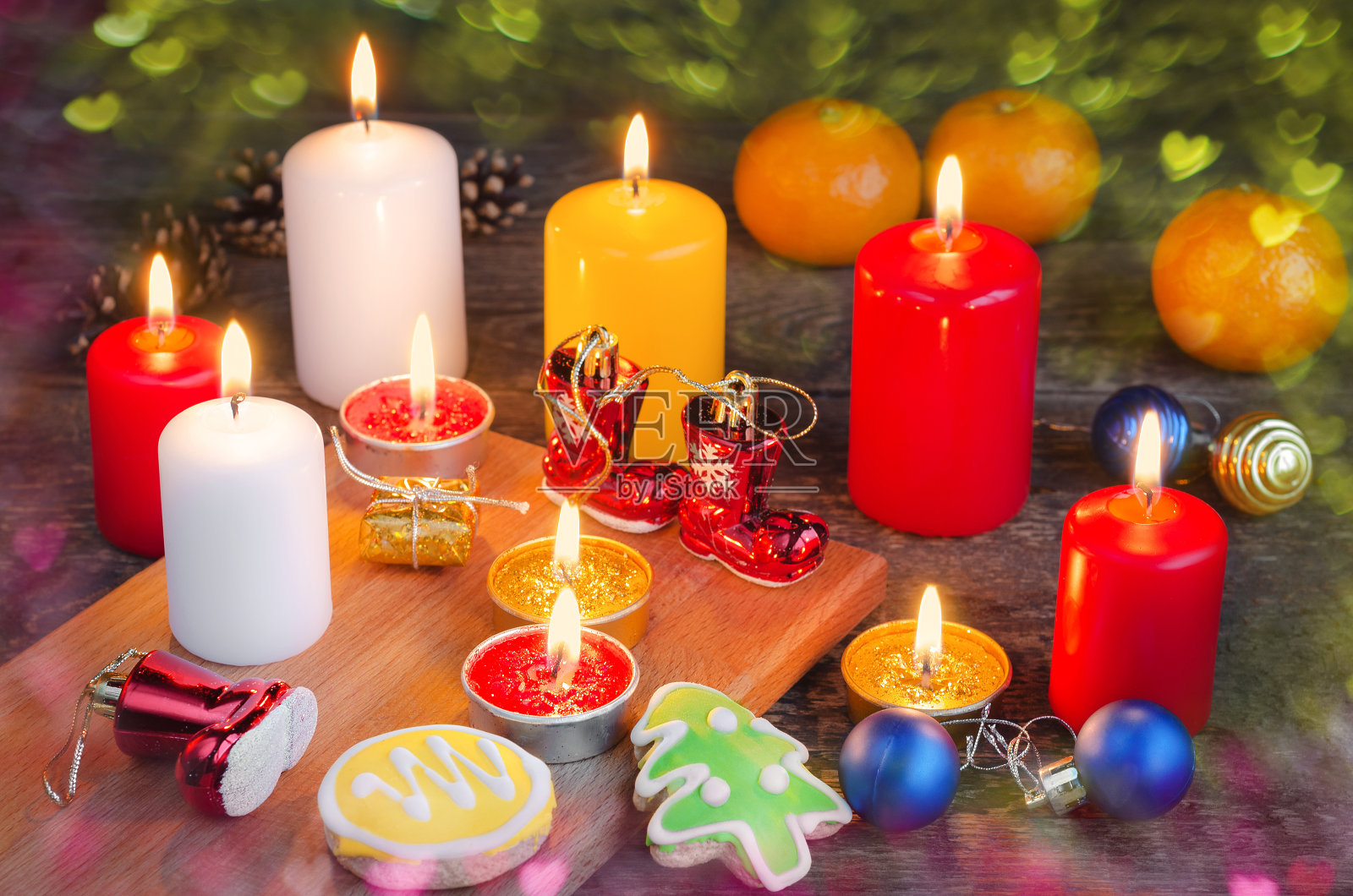 木制背景上燃烧着圣诞装饰和姜饼的蜡烛。有选择性的重点照片摄影图片