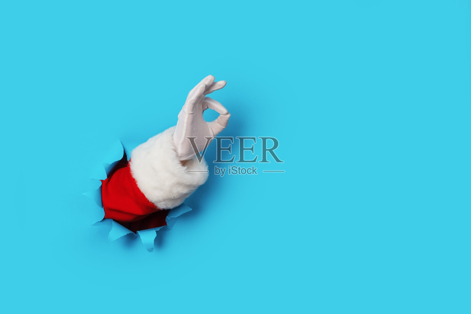 圣诞老人的手显示OK孤立在浅蓝色照片摄影图片