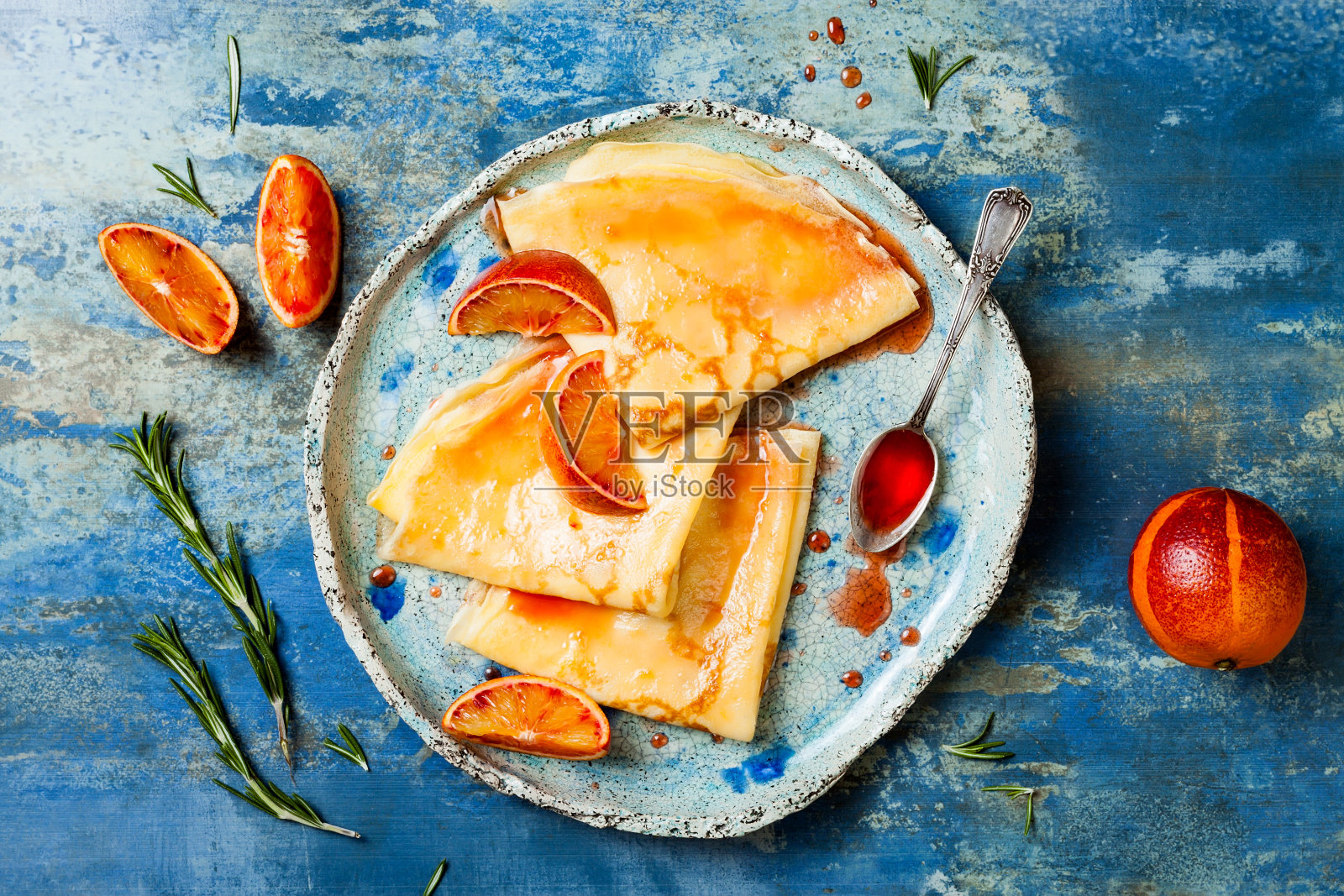 自制的可丽饼、薄煎饼，盛在陶瓷盘子里，配上橙汁。法国可丽饼配血橙糖浆。照片摄影图片