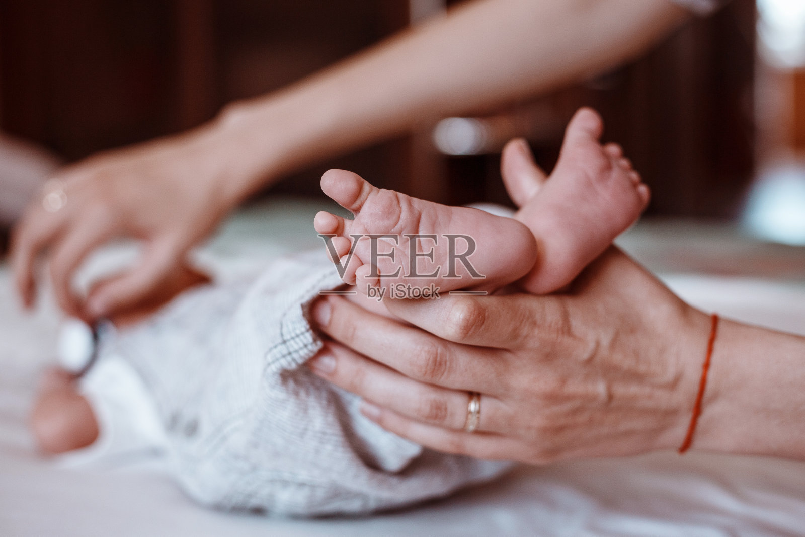 女性手中新生婴儿的脚部特写照片摄影图片