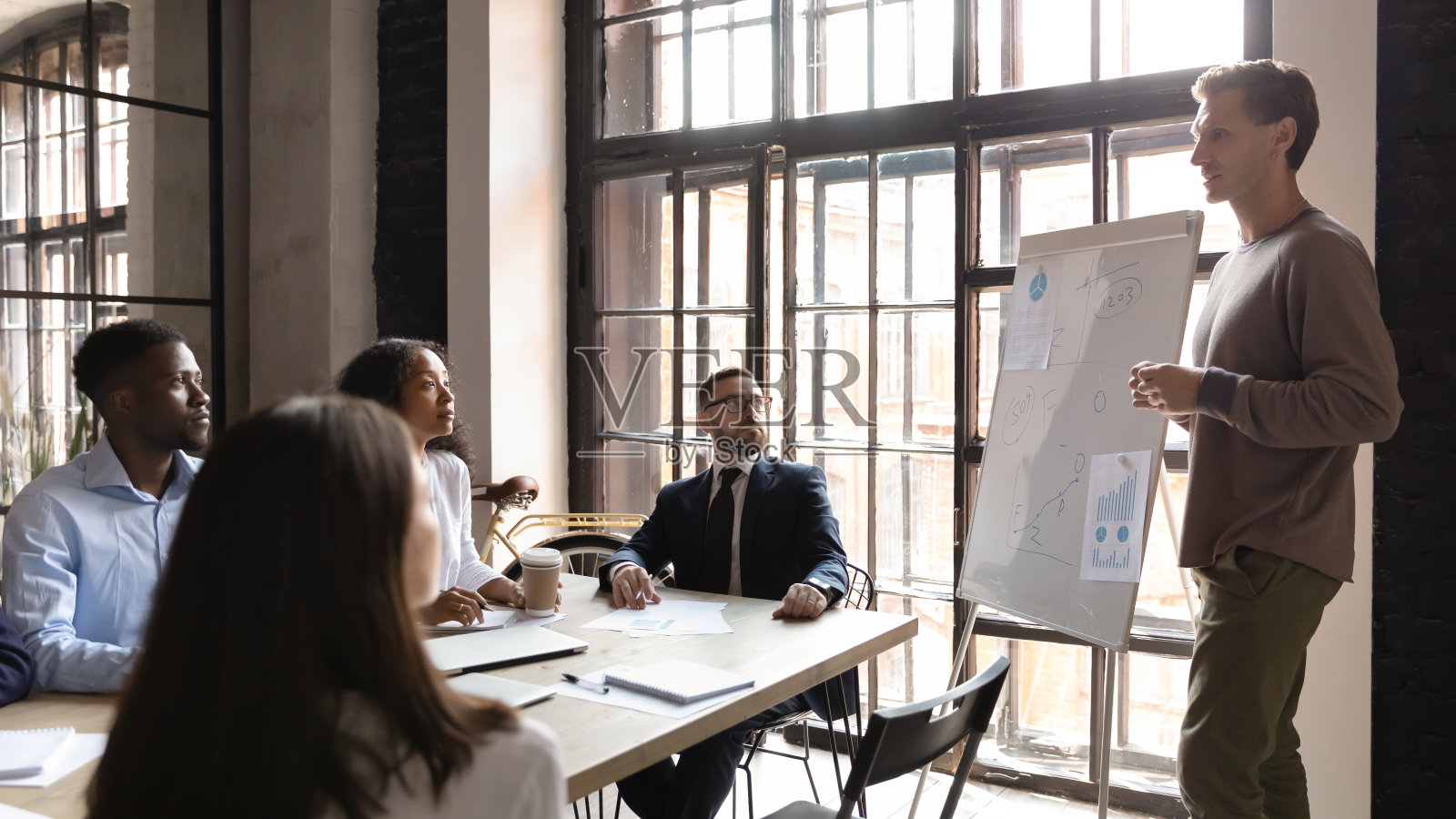 专注于混合种族的年轻经理听取同事的意见。照片摄影图片