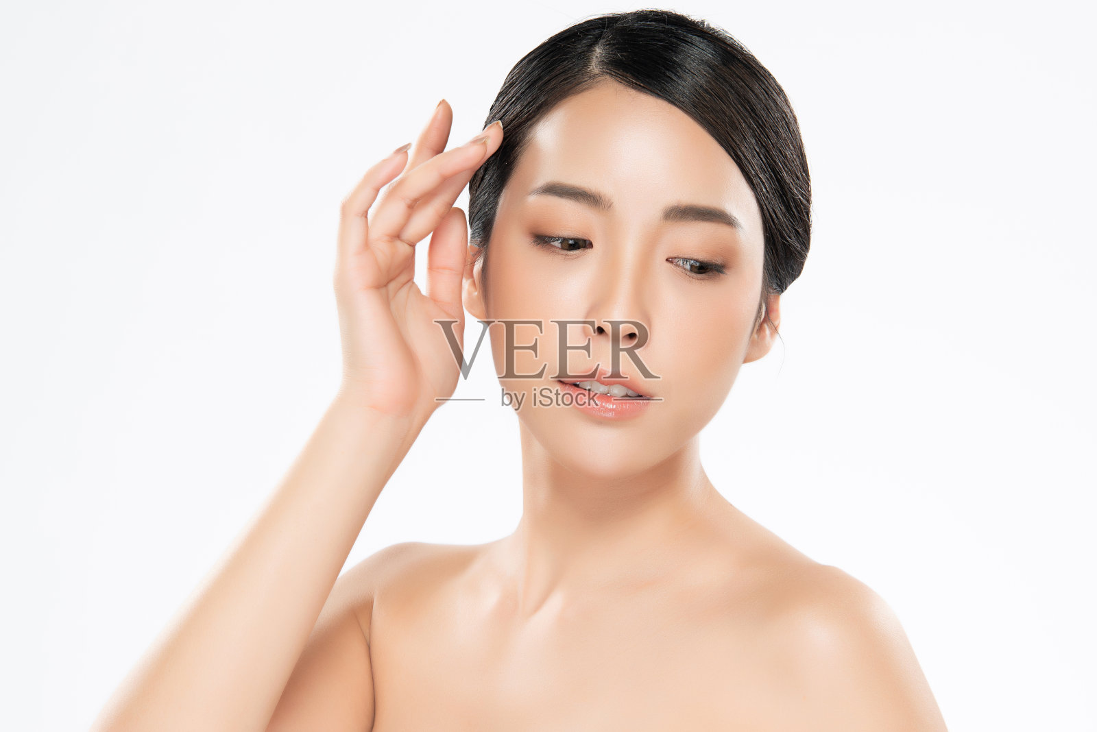 年轻的亚洲妇女触摸柔软的脸颊和微笑，干净和新鲜的皮肤。幸福与欢快，白色背景上的孤立，美丽与化妆品的概念，照片摄影图片