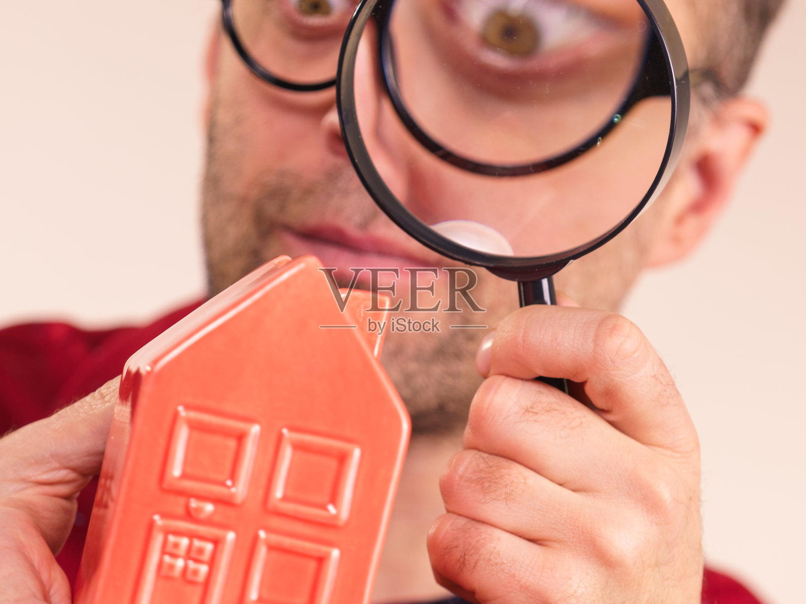 男人用放大镜观察红房子照片摄影图片