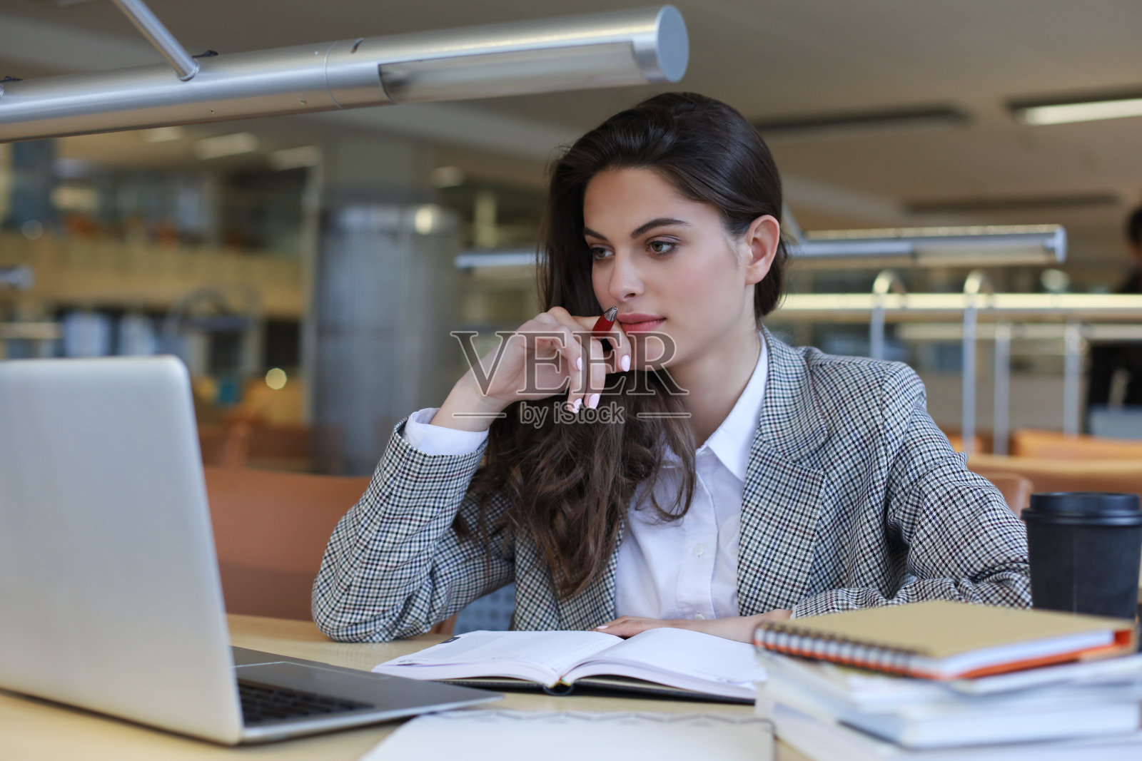 图书馆里使用笔记本电脑的女学生肖像照片摄影图片