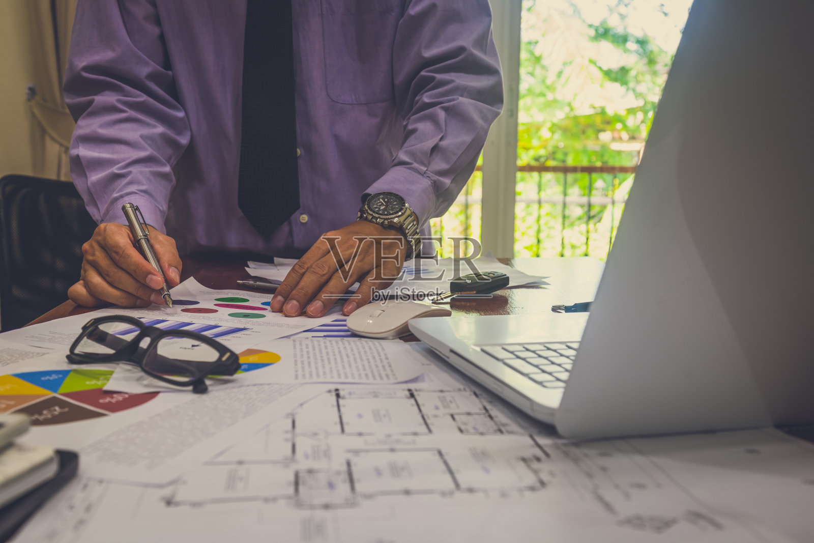 商人或会计使用计算器计算商业数据，会计投资顾问咨询财务报告并制定营销计划照片摄影图片