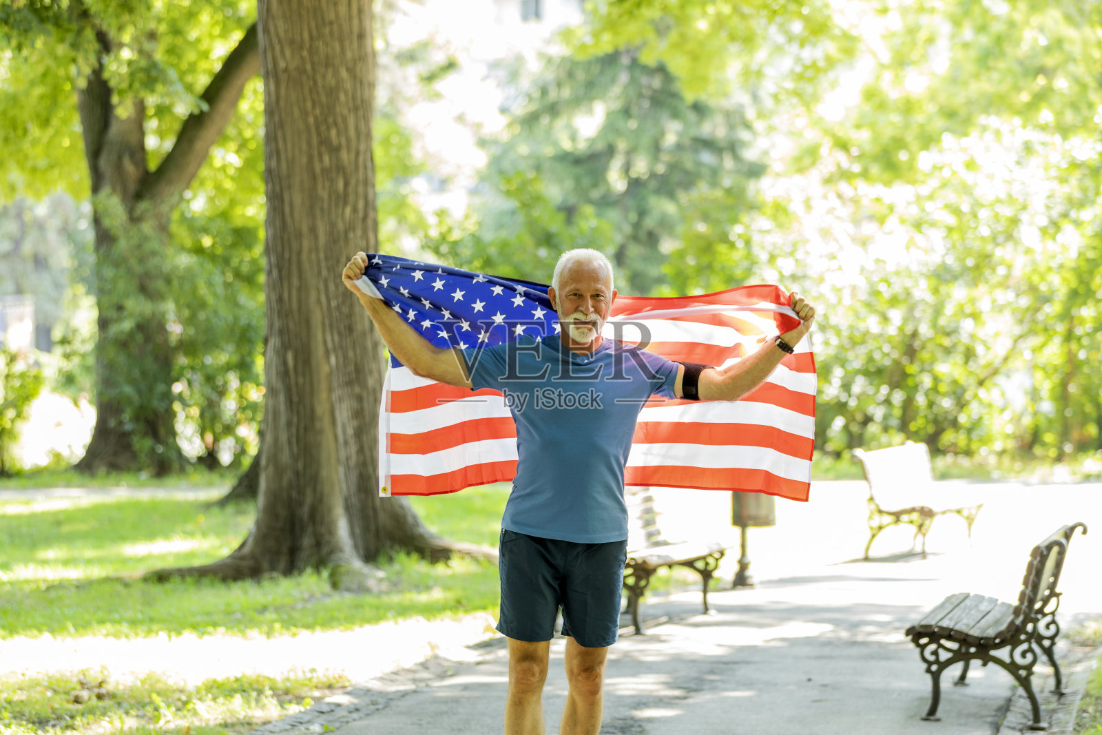 公园里举着美国国旗的老人照片摄影图片