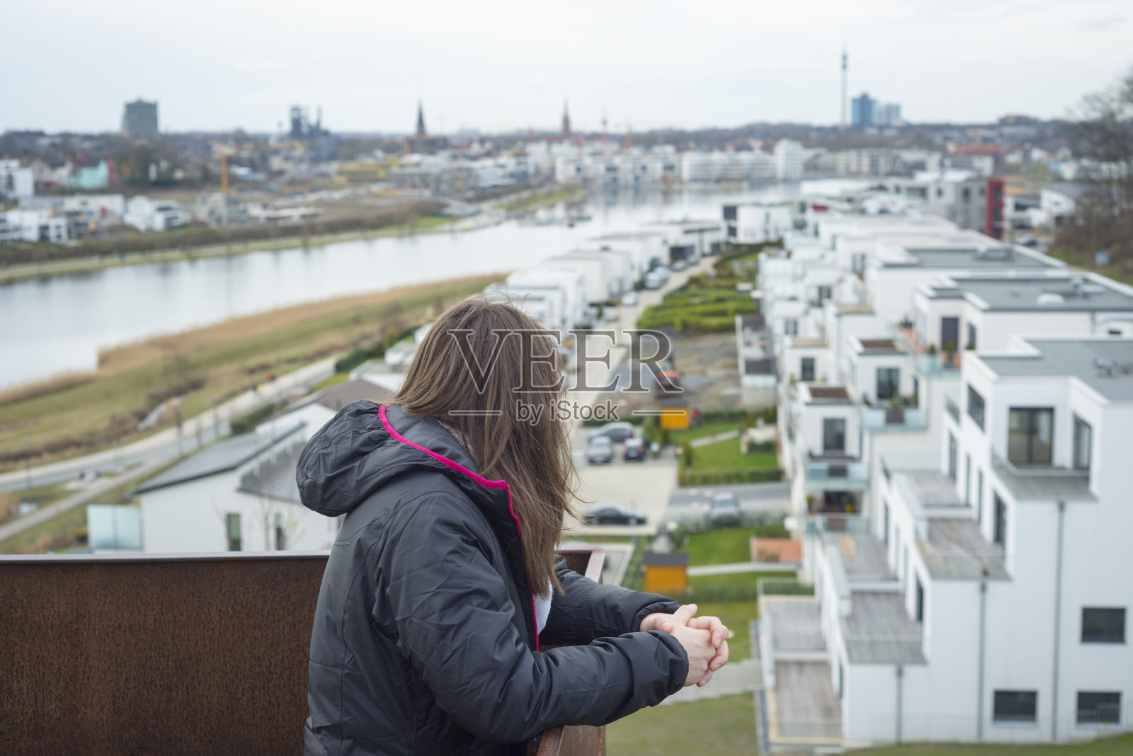 一个美丽的女人坐在湖边的沙滩上欣赏美丽的风景照片摄影图片