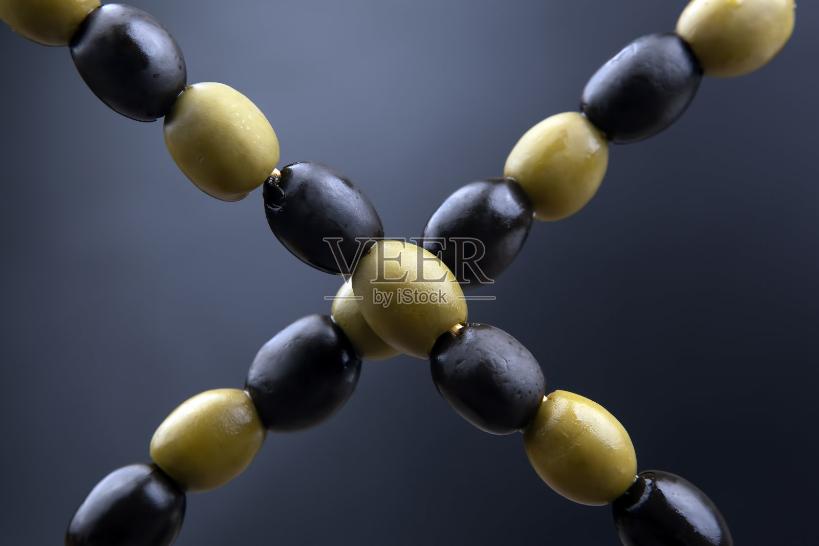 黑色和绿色的橄榄在一个黑暗的背景特写。食物和蔬菜。饮食与减肥照片摄影图片