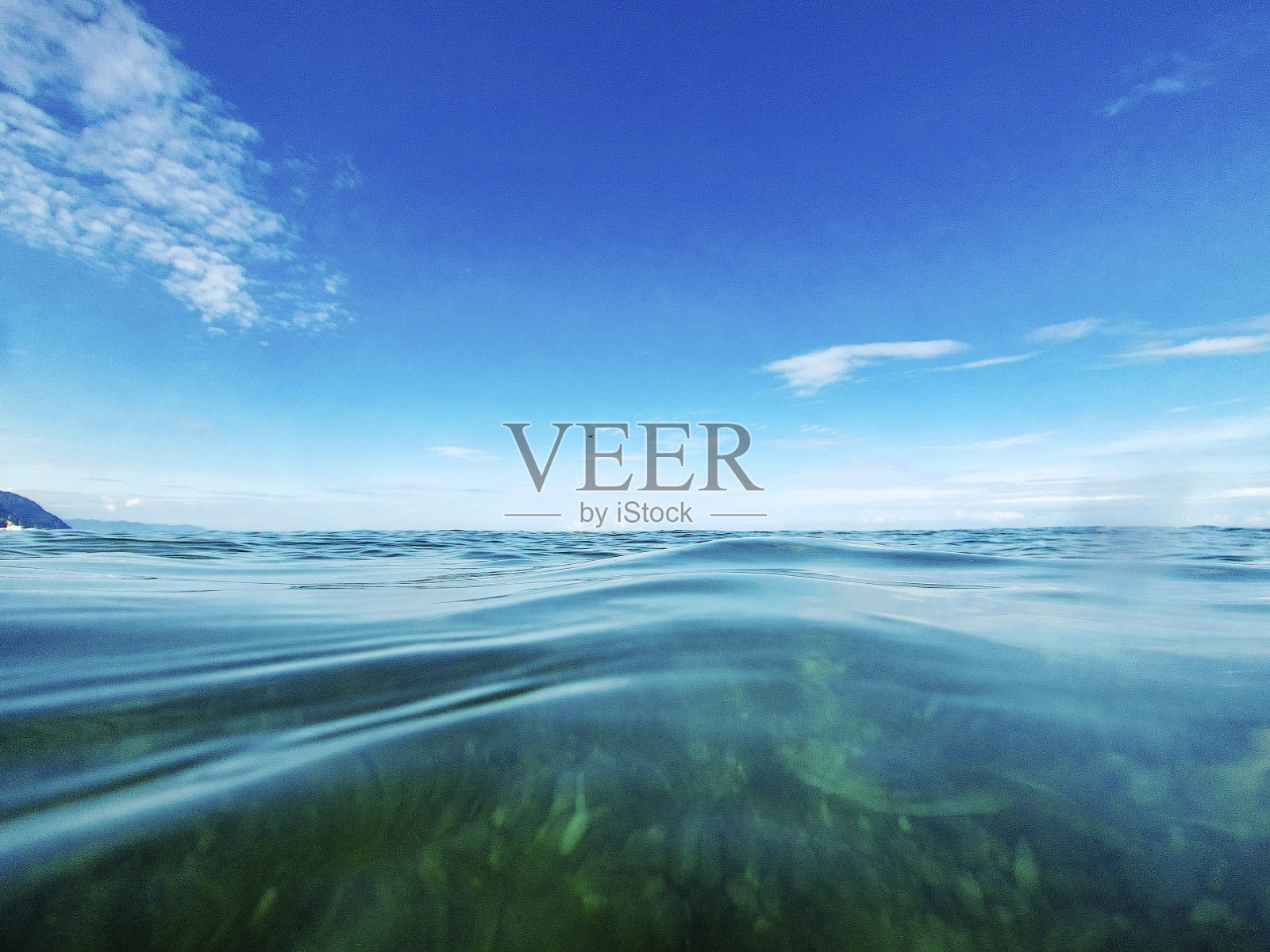 海景。晴朗的日子里，蔚蓝的海面上乌云密布的蓝天。照片摄影图片