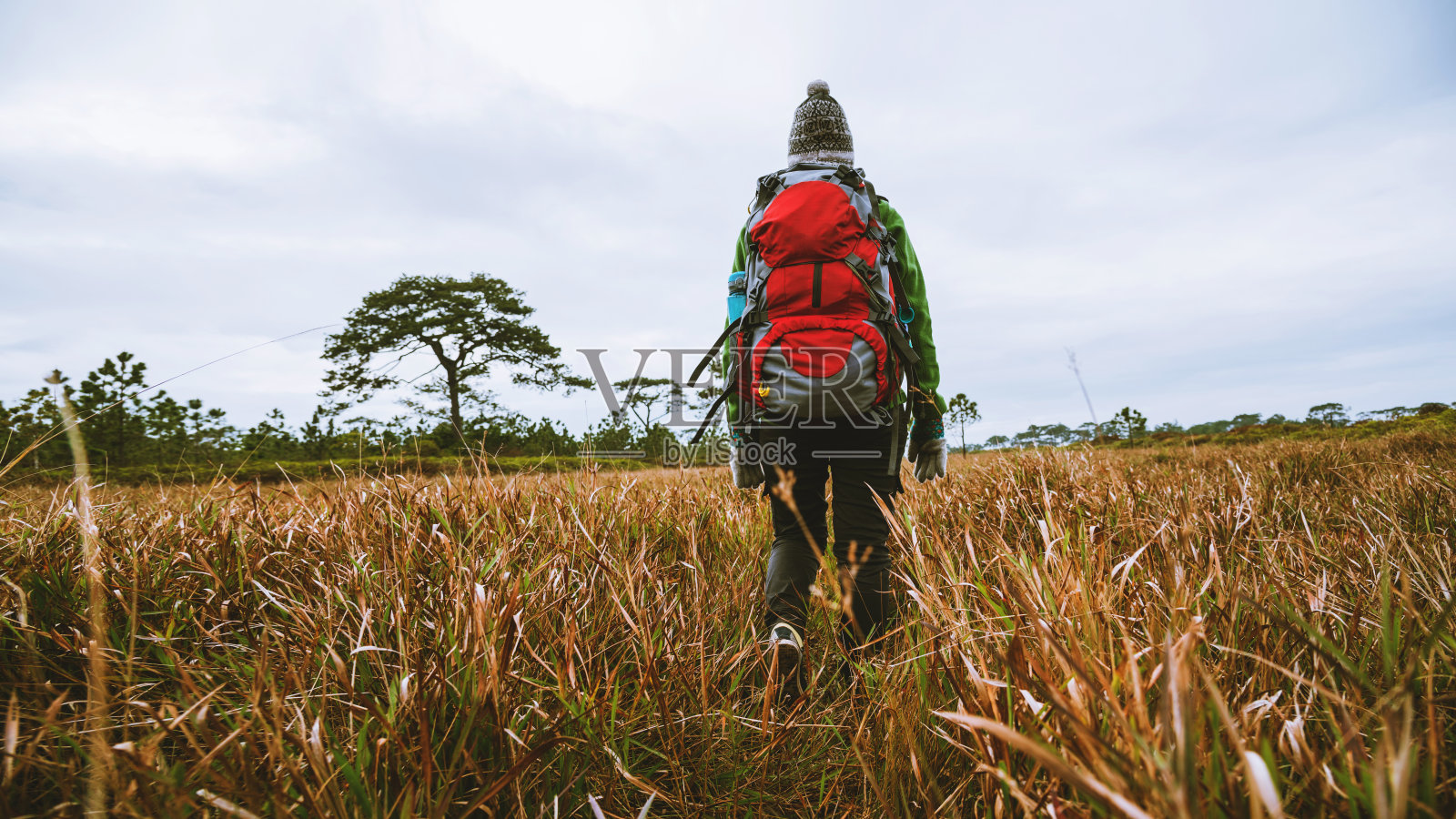 亚洲女性旅游自然。旅行放松。站在天然摸草的山上。背着背包的女孩走在草丛里。旅游自然。旅行放松。照片摄影图片