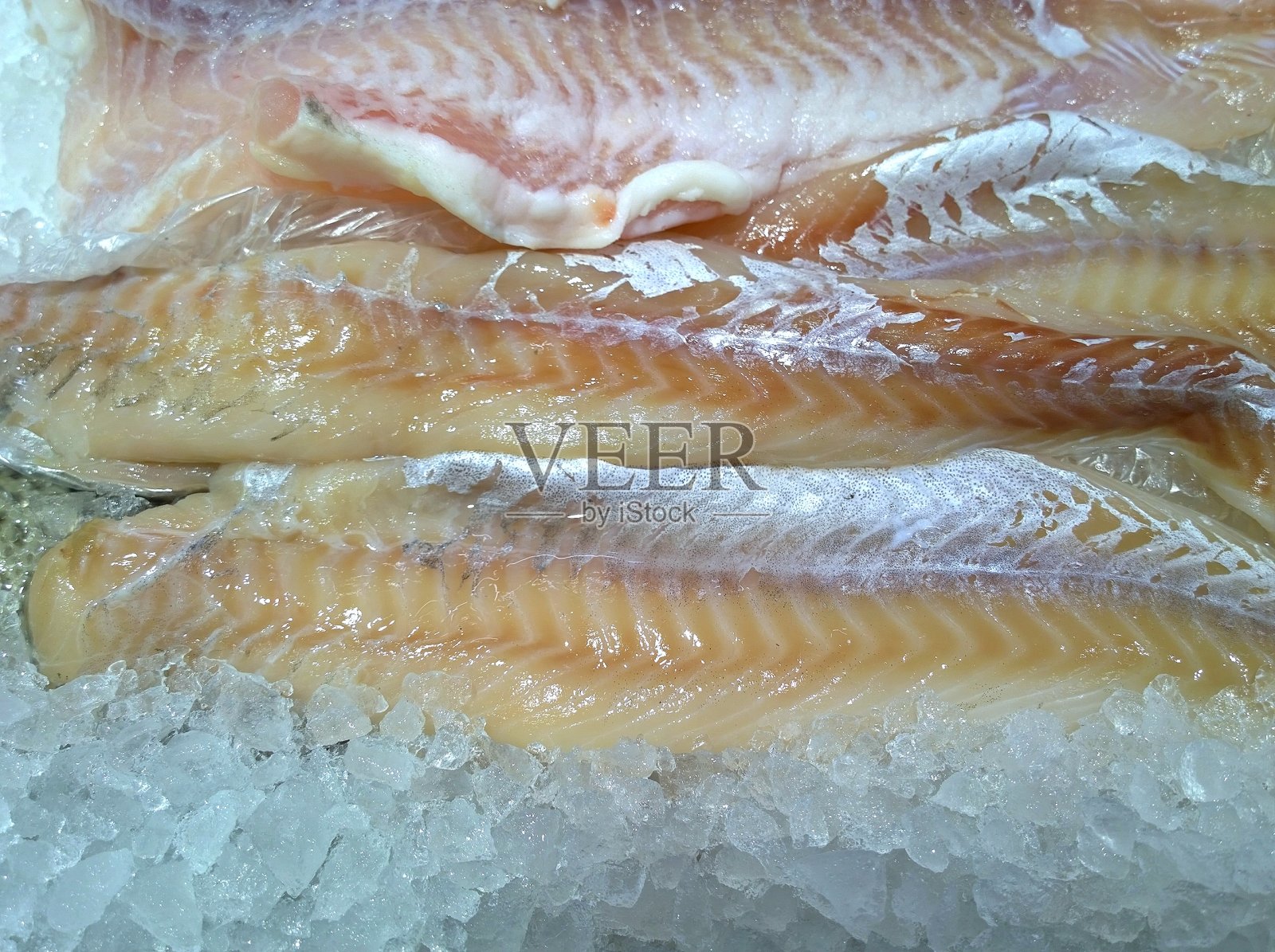 冰冻美味的鱼片加冰。供应和销售优质新鲜海鲜的理念。食品的背景。照片摄影图片