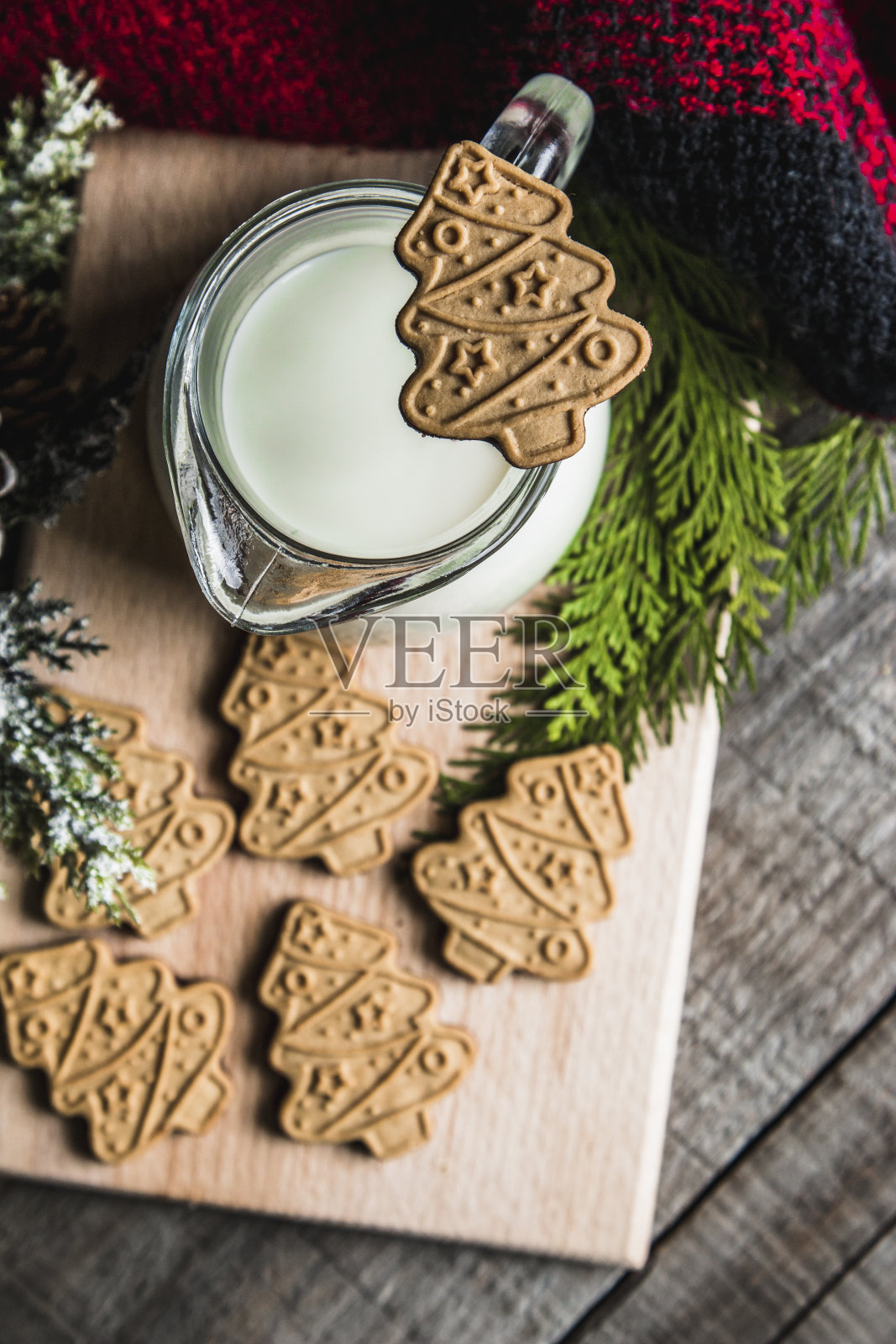 木桌上放着新鲜牛奶和圣诞饼干，还有圣诞装饰品照片摄影图片