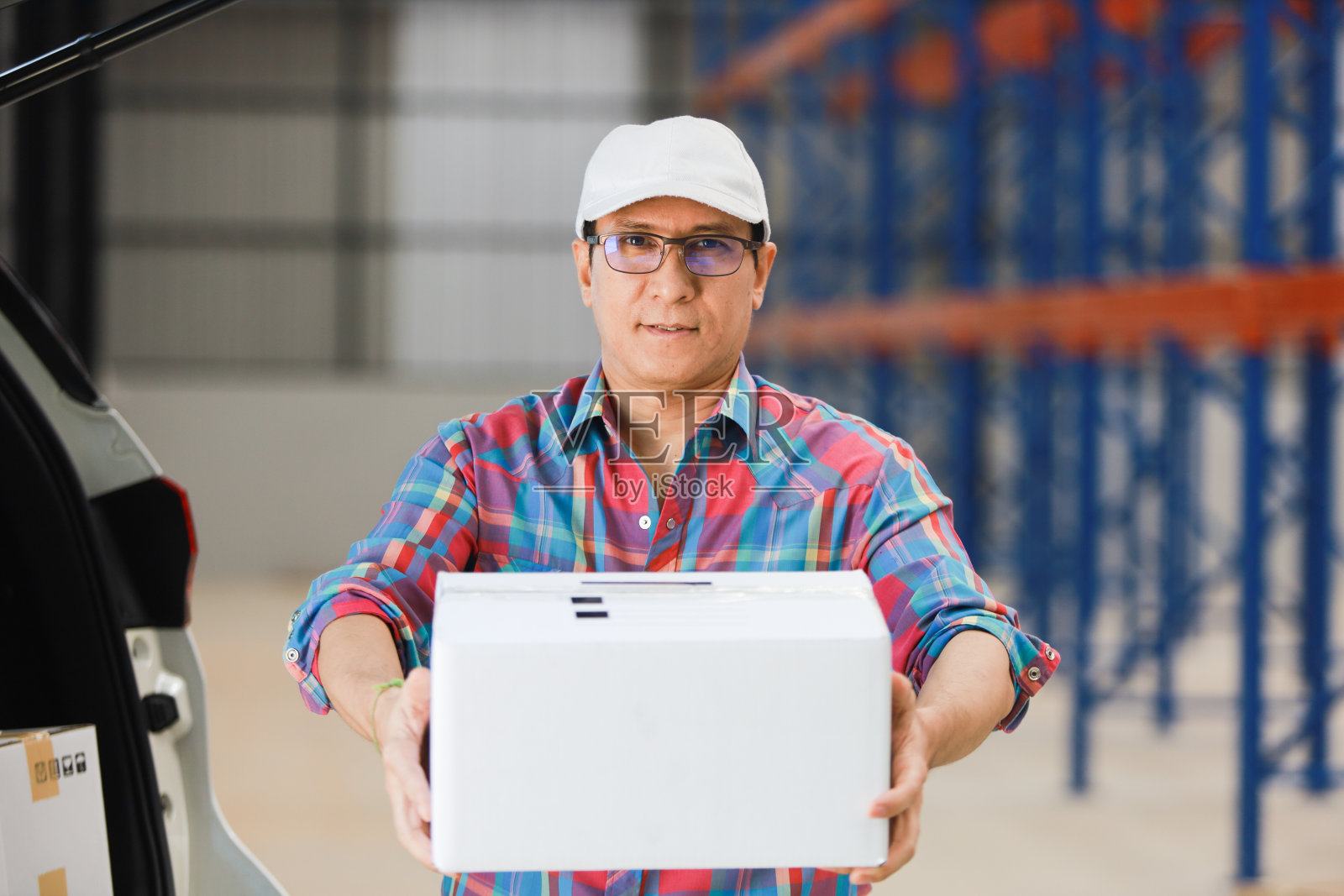 亚洲男人在工厂向顾客交付货物，并在平板电脑上签字，提供微笑和良好服务，物流在线购物概念照片摄影图片