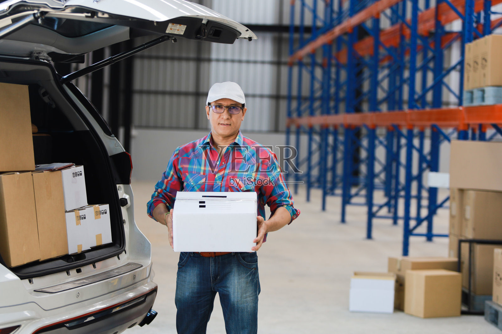 亚洲男人在工厂向顾客交付货物，并在平板电脑上签字，提供微笑和良好服务，物流在线购物概念照片摄影图片