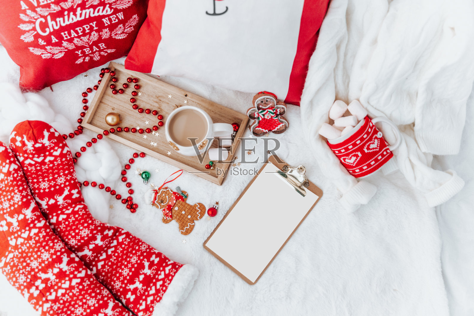 圣诞组成。空白便条，贺卡模拟场景。咖啡杯，红袜子，床上有棉花糖。平坦的躺着,上面。“n”n照片摄影图片