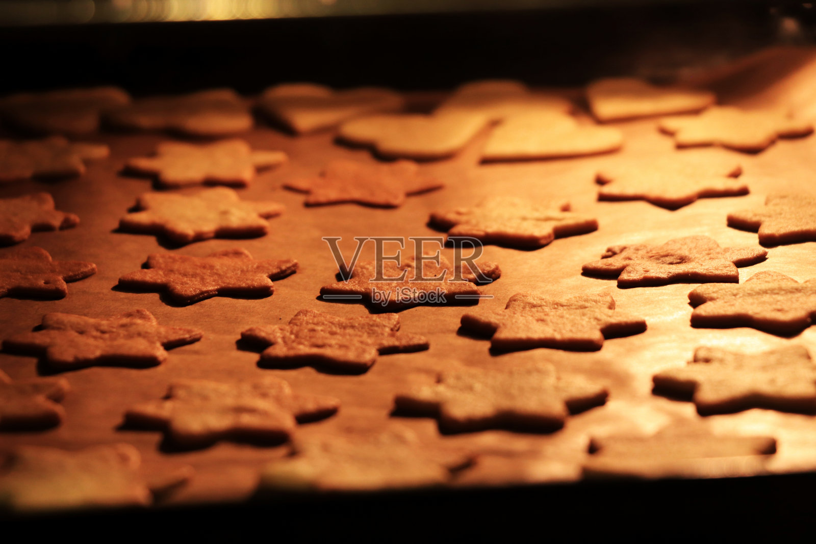 复活节，感恩节和其他节日的圣诞饼干。雪人，心，树和许多更多的炉子。妈妈和孩子在烤箱里烤姜饼。寒假的概念照片摄影图片