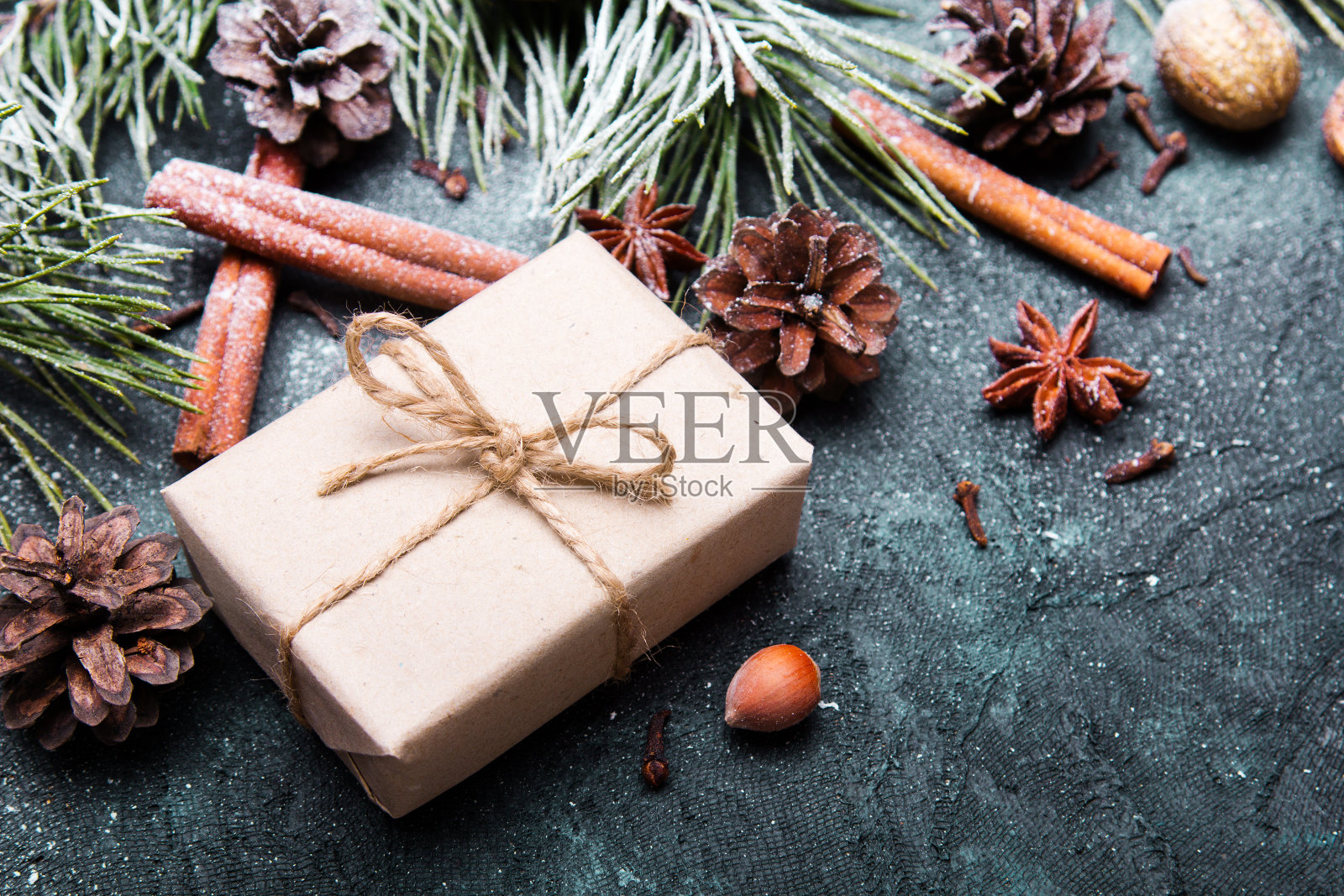 圣诞背景装饰。圣诞礼物，松枝和松果覆盖着雪在黑暗的背景照片摄影图片