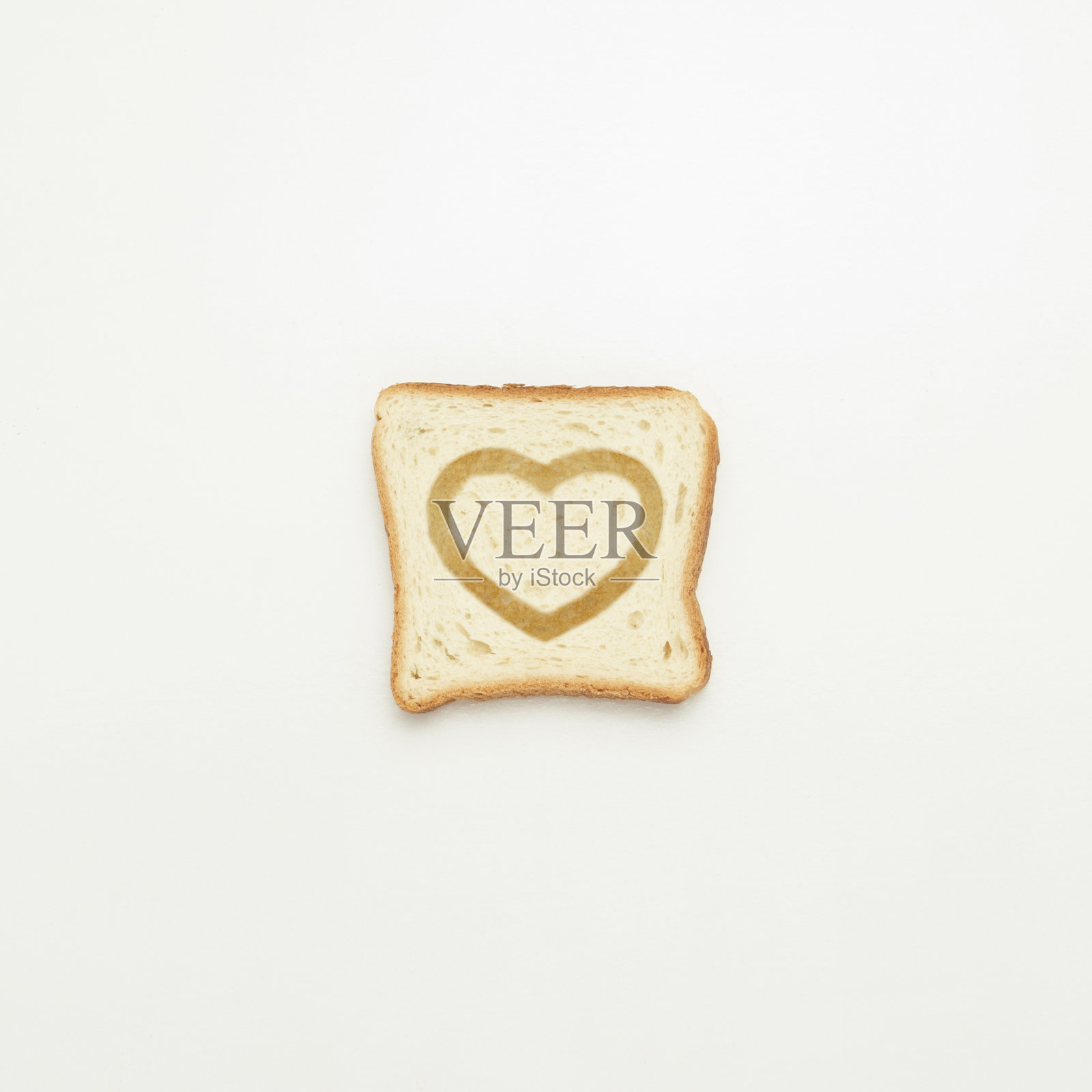 白色背景上有一颗心的吐司片。照片摄影图片