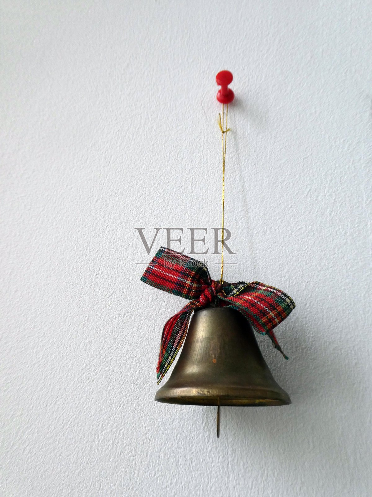装饰圣诞的钟声系着丝带挂在墙上照片摄影图片