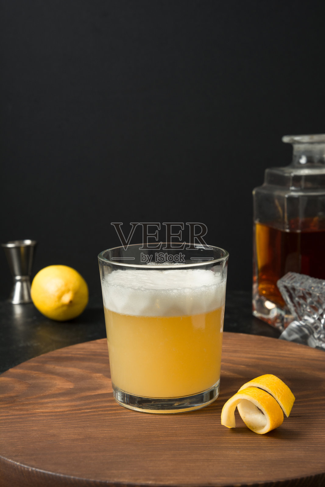 威士忌酸鸡尾酒-波旁威士忌加柠檬汁，糖浆和蛋清玻璃杯。垂直方向。照片摄影图片