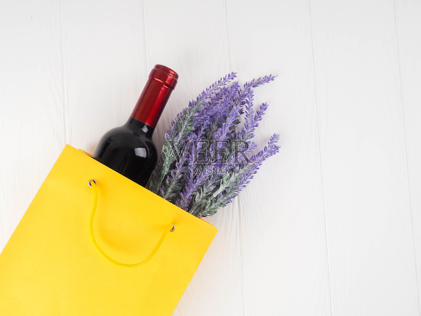 酒瓶子里装着礼品，鲜花，放在木质背景上，复制空间，礼品，节日，约会，平铺照片摄影图片