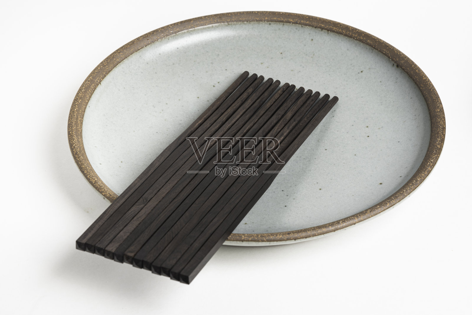 六双筷子放在炻器盘子上照片摄影图片