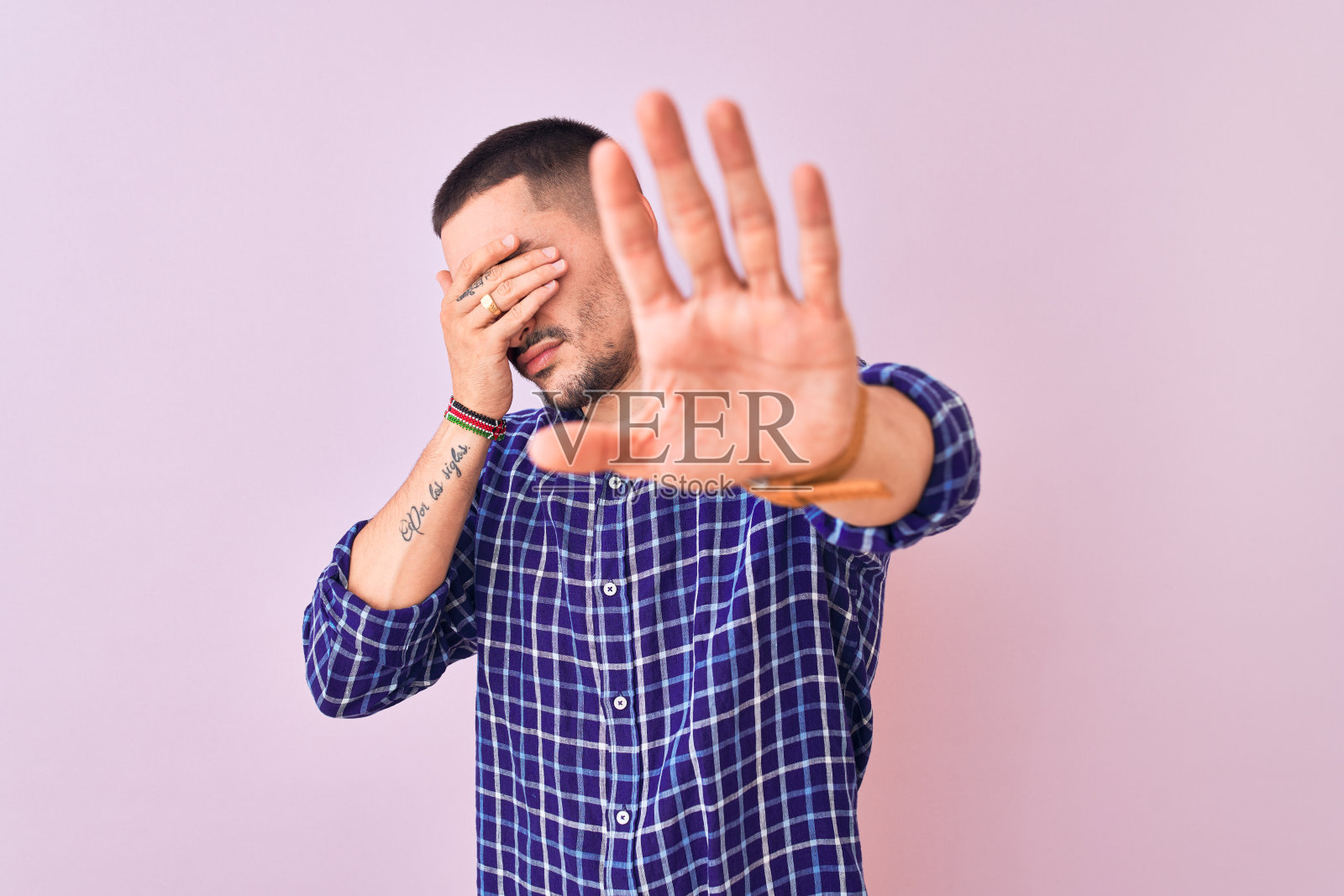 年轻英俊的男子站在孤立的背景覆盖的眼睛和做停止手势与悲伤和恐惧的表情。尴尬和消极的概念。照片摄影图片