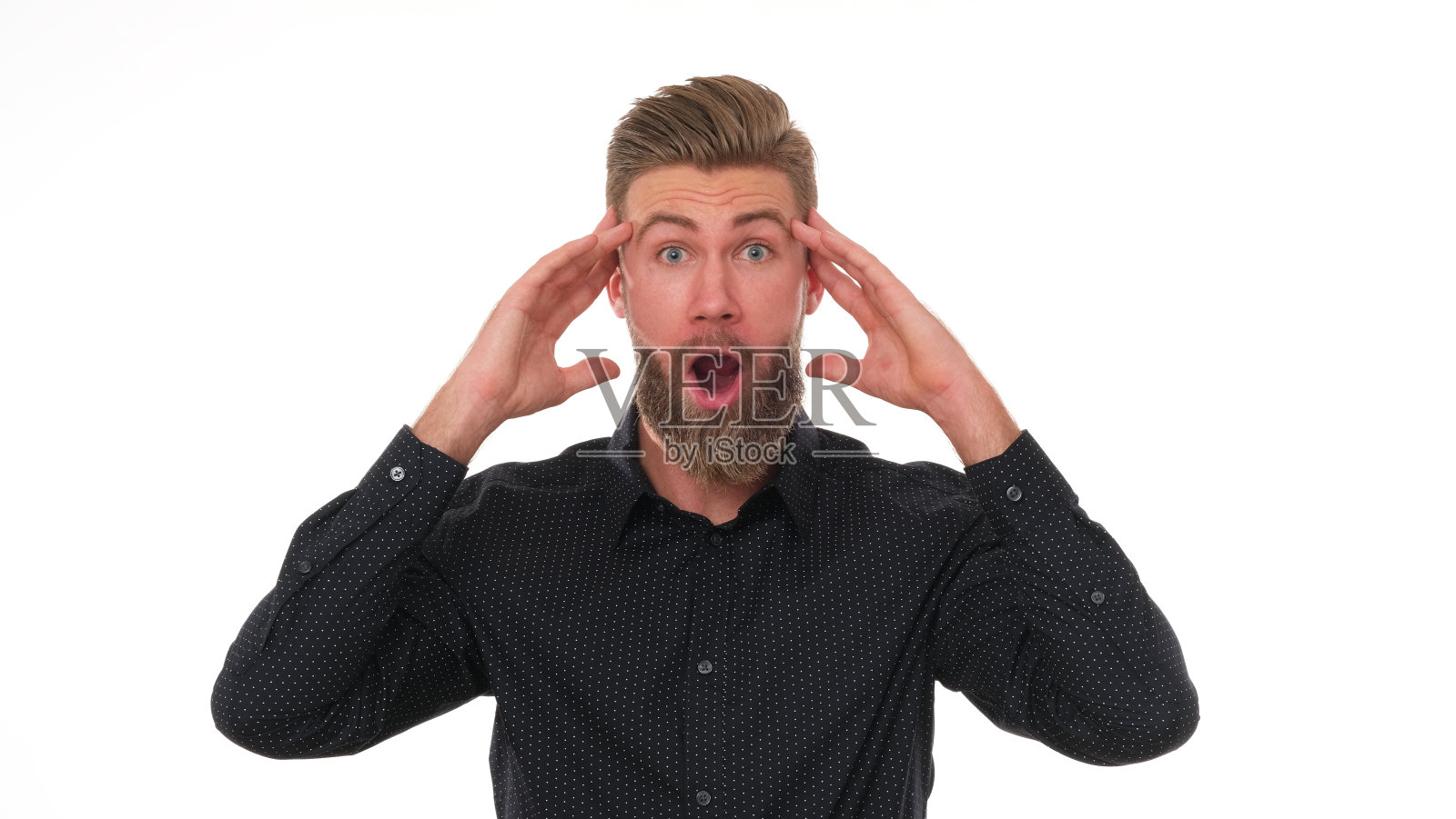 留着胡子、穿着黑衬衫的年轻人表情丰富。照片摄影图片