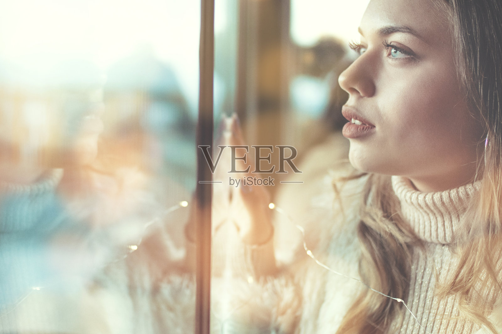 沉思的女人看着窗外的侧面视角照片摄影图片