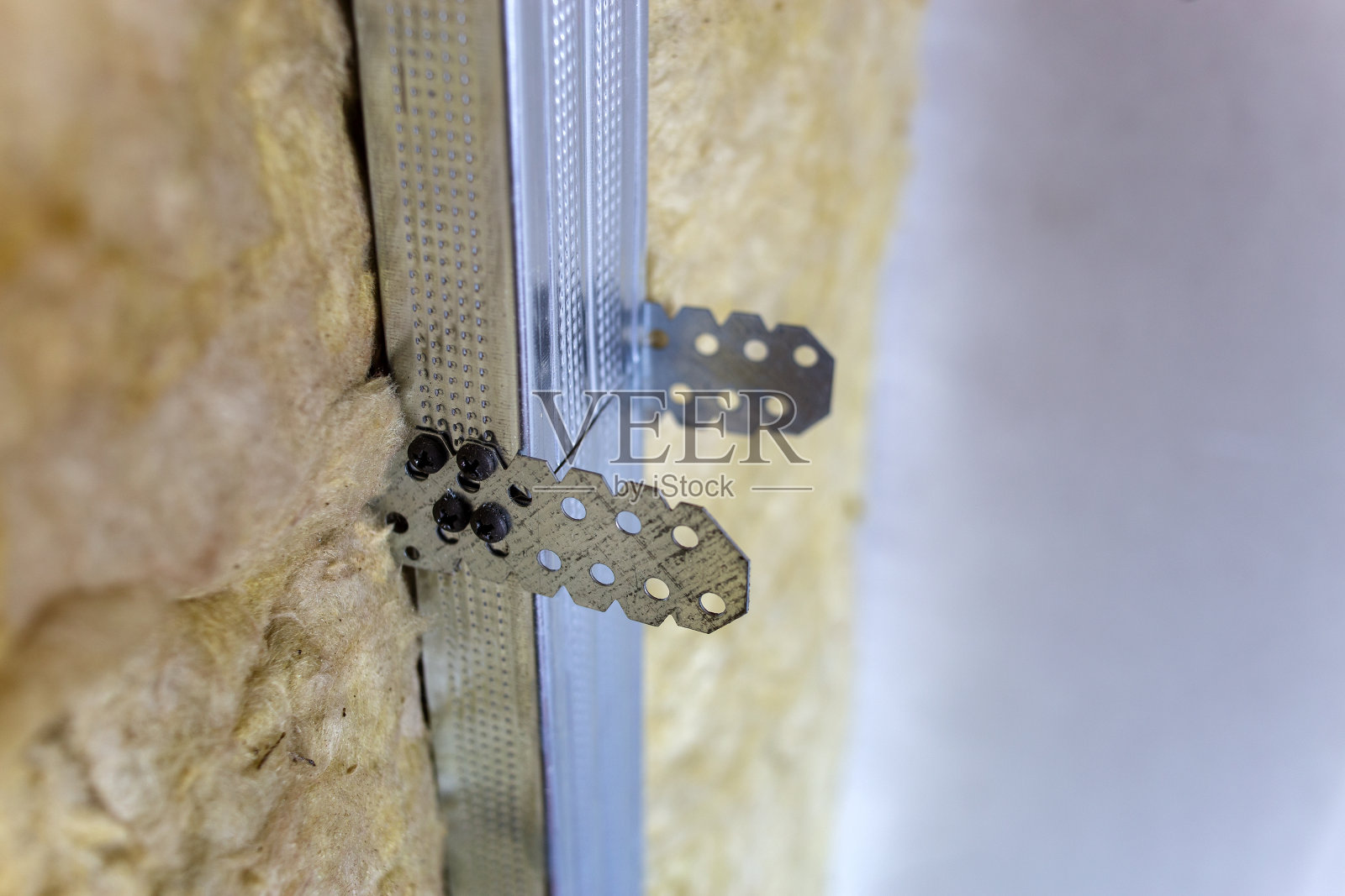 正在翻新的房间墙壁，采用矿物岩棉绝缘材料和为干墙板准备的金属框架。照片摄影图片