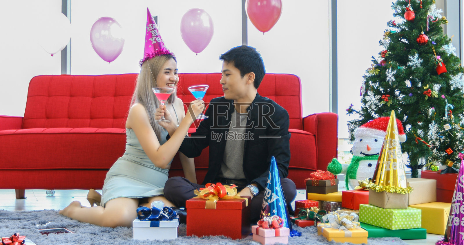 亚洲情侣爱好者在酒吧享用含酒精的啤酒饮料，年轻人在圣诞节和新年派对上用圣诞礼物敬酒照片摄影图片