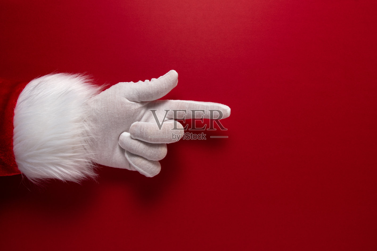 圣诞老人的手套手正在做手势。圣诞节或新年简约概念。照片摄影图片