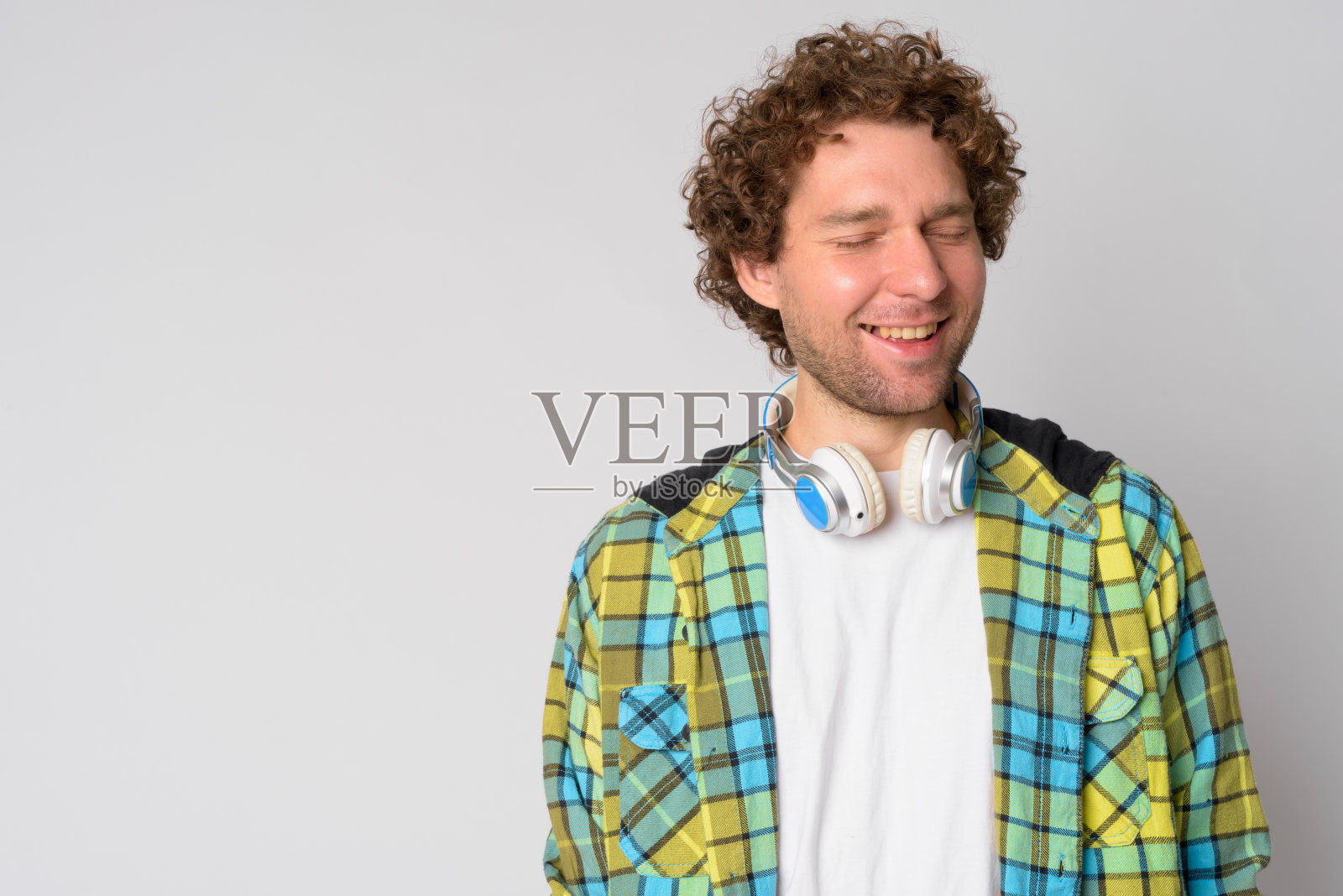 一幅快乐的潮人肖像，卷头发，闭着眼睛笑照片摄影图片