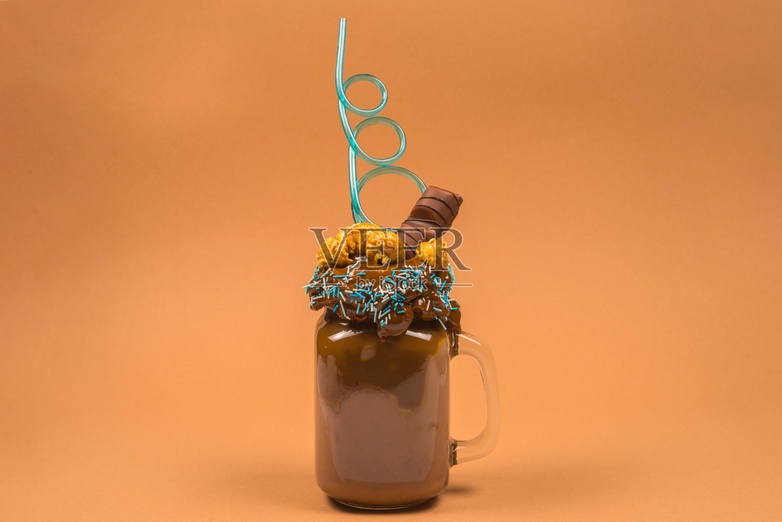 巧克力奶昔加鲜奶油，饼干，华夫饼，盛在玻璃玻璃罐中。"怪胎还是疯子"的甜奶昔。照片摄影图片