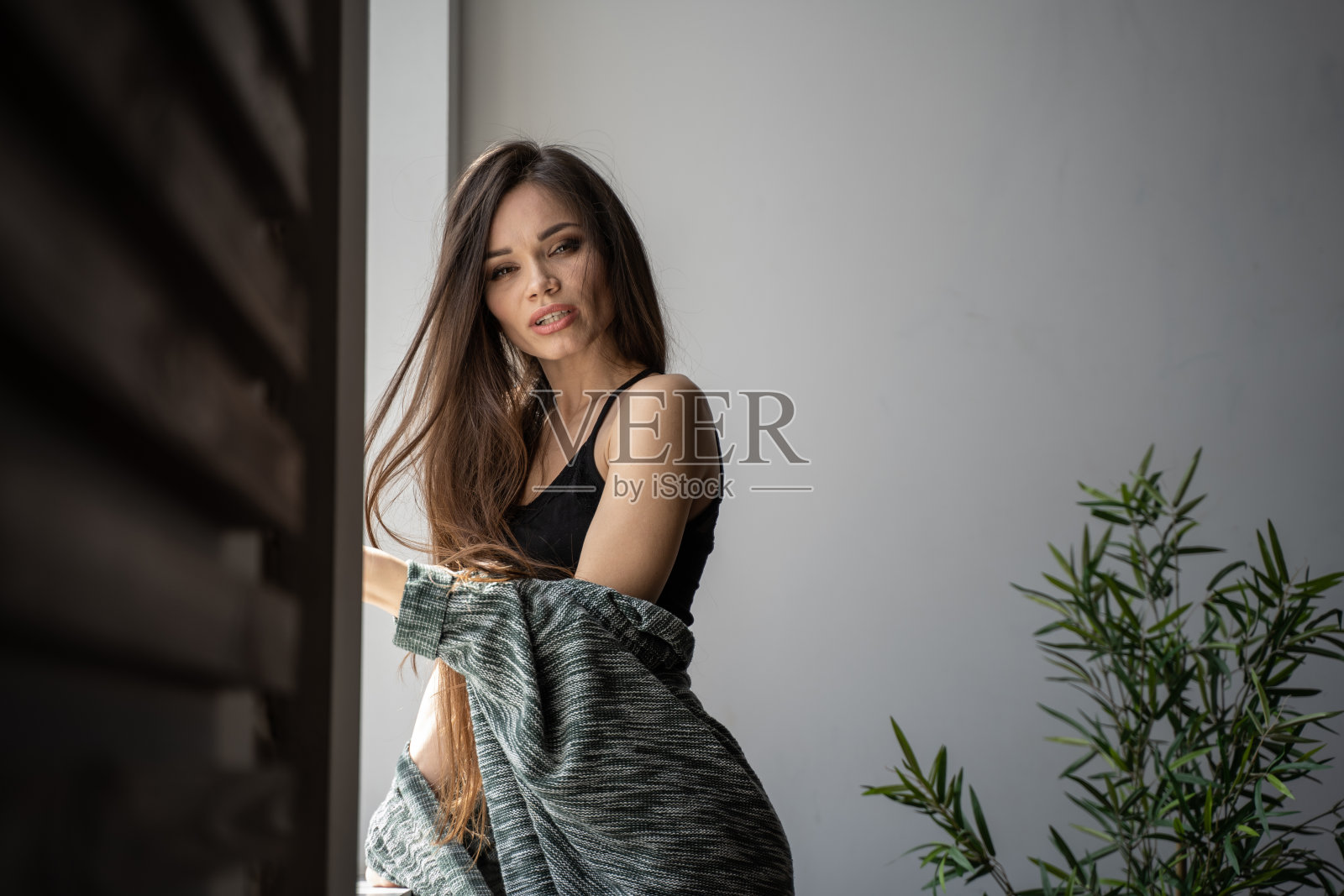 在阳光下的窗口，长头发的女孩照片摄影图片