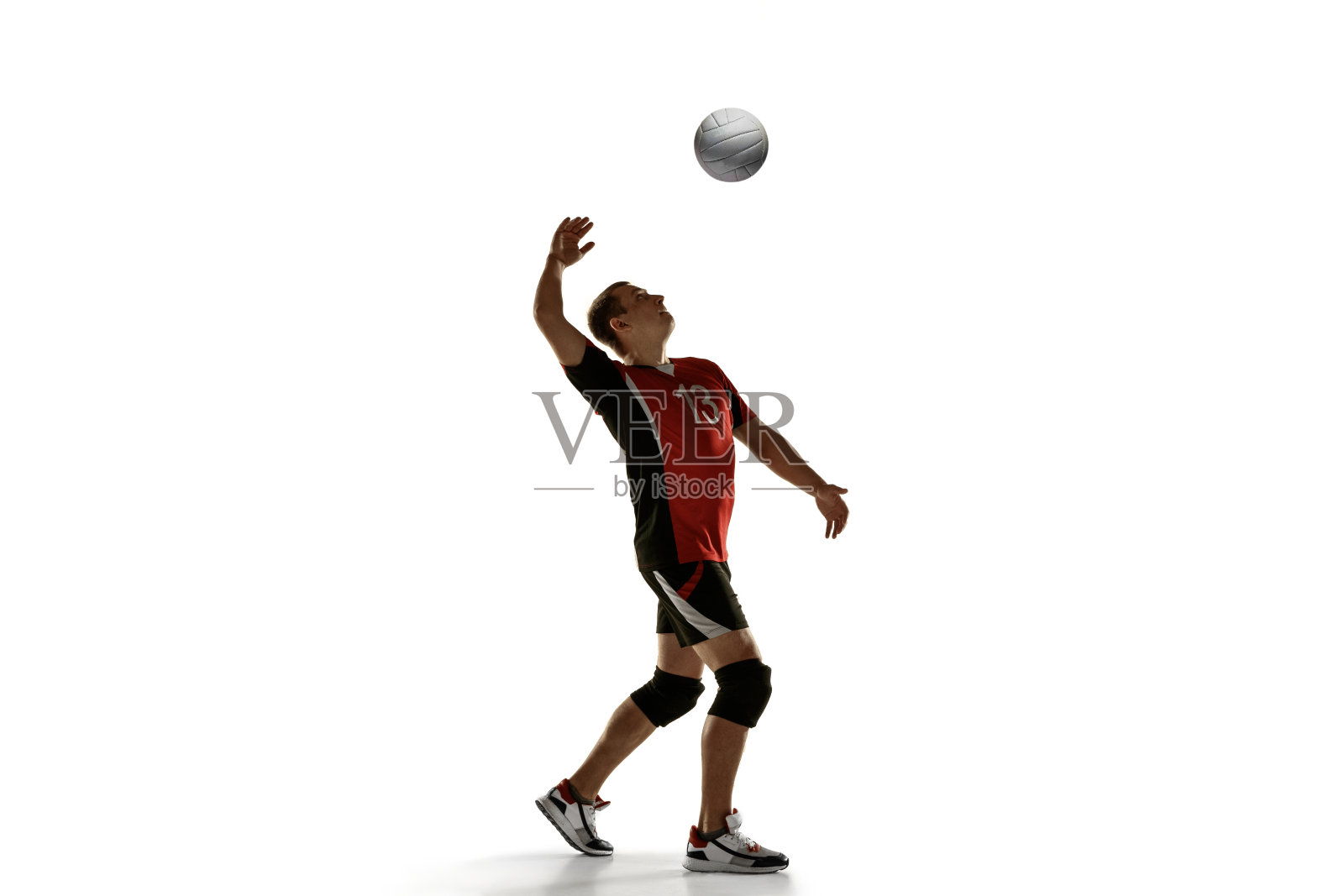 年轻的白人排球运动员在白色背景上练习照片摄影图片