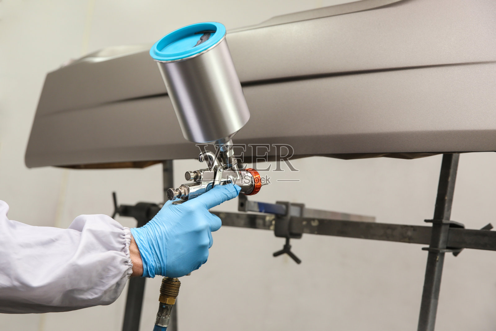 汽车油漆工的手正在用喷枪画汽车细节。在喷漆室用粉碎机喷涂汽车零件照片摄影图片