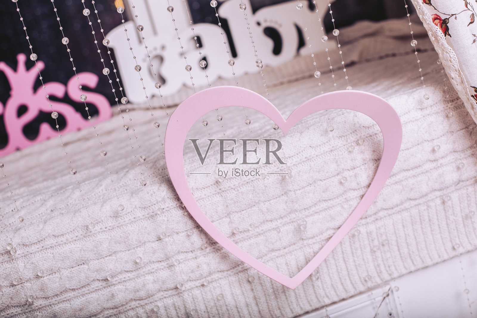 背景上挂着粉色的心和婴儿标志。情人节的装饰品照片摄影图片