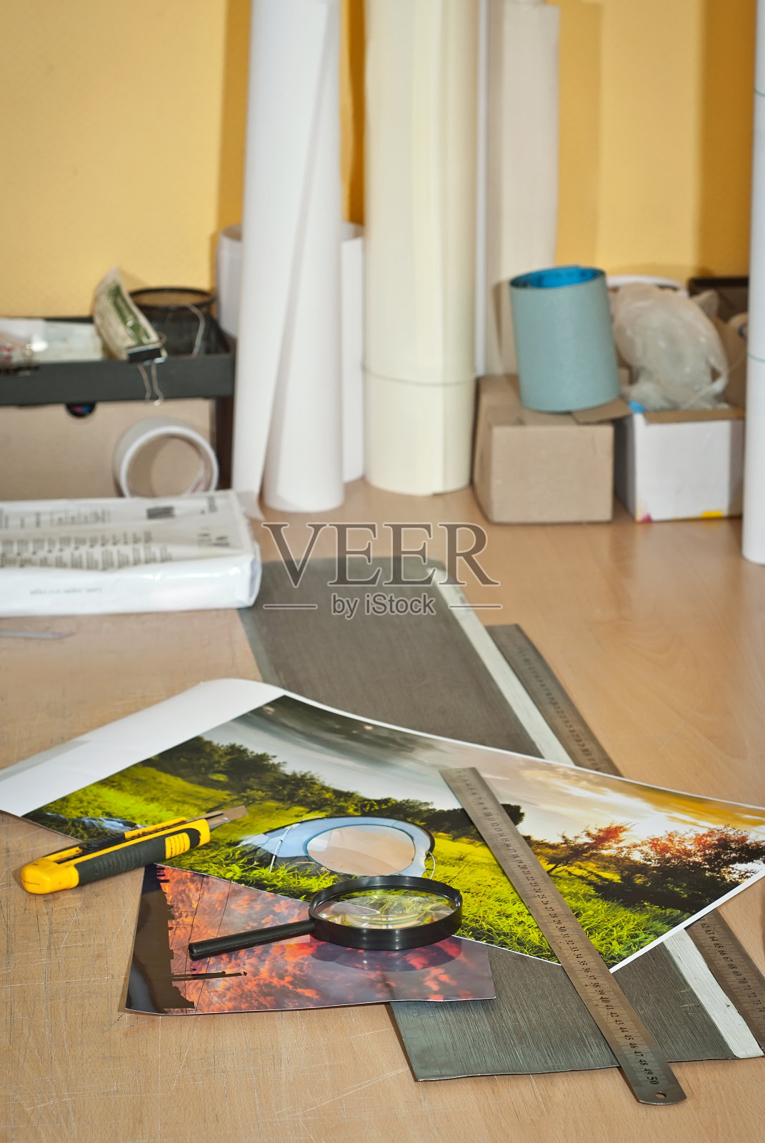 手动作物照片。照片印在桌上。刀子和尺子在桌子上。用文具刀装镜框。照片摄影图片