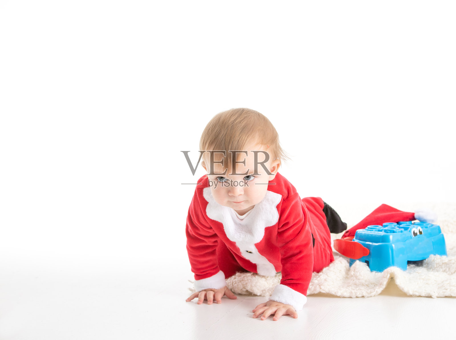 打扮成圣诞老人的宝宝在爬行照片摄影图片