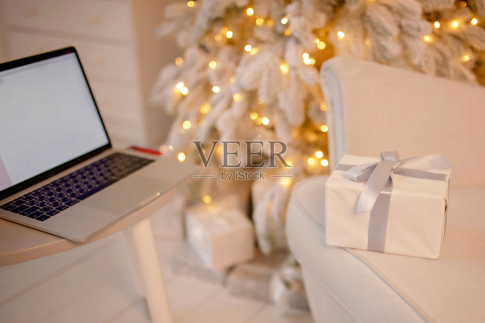 千禧一代的成年人在笔记本电脑上制作节日礼物。圣诞快乐，恭贺新禧照片摄影图片