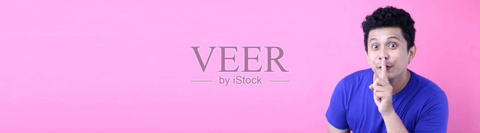 近距离拍摄的英俊狡猾的亚洲男子嘘手势，要求安静或安静，孤立在工作室的粉红色背景与复制空间。照片摄影图片