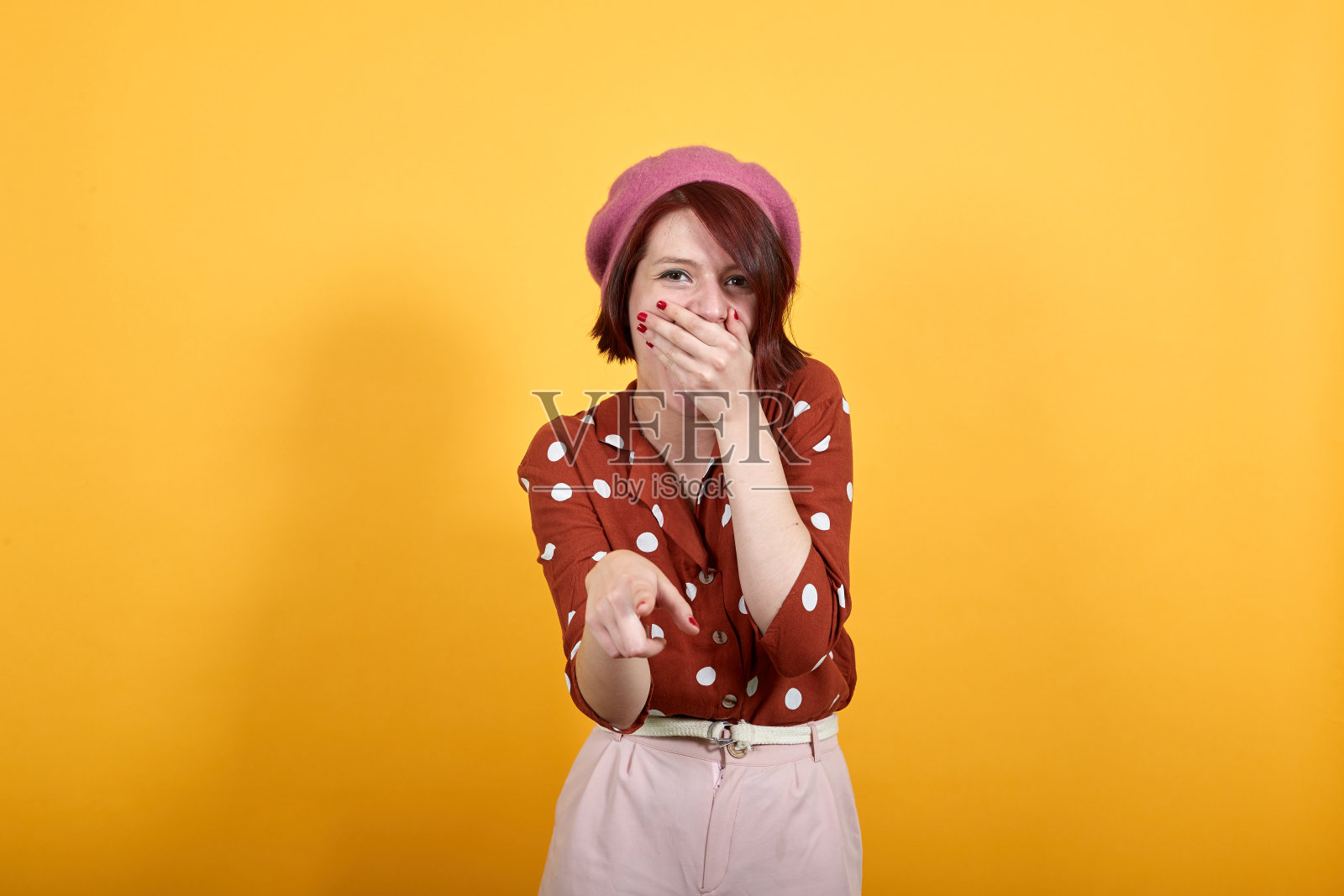 美丽的女孩笑着你，用手指着嘴指着相机照片摄影图片