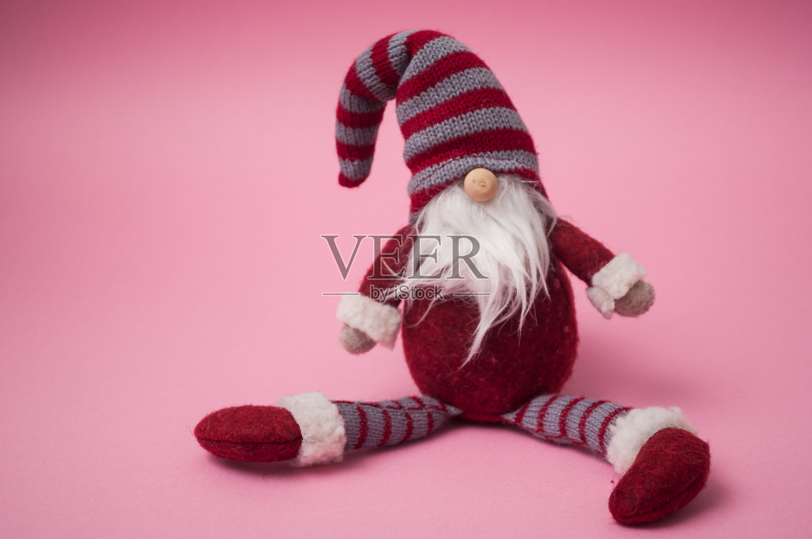 粉红色背景上的圣诞侏儒照片摄影图片