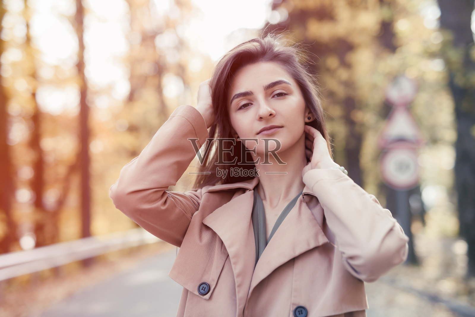 秋天的公园。美丽的女人穿着绿色的衣服摆姿势在秋天公园与黄叶照片摄影图片