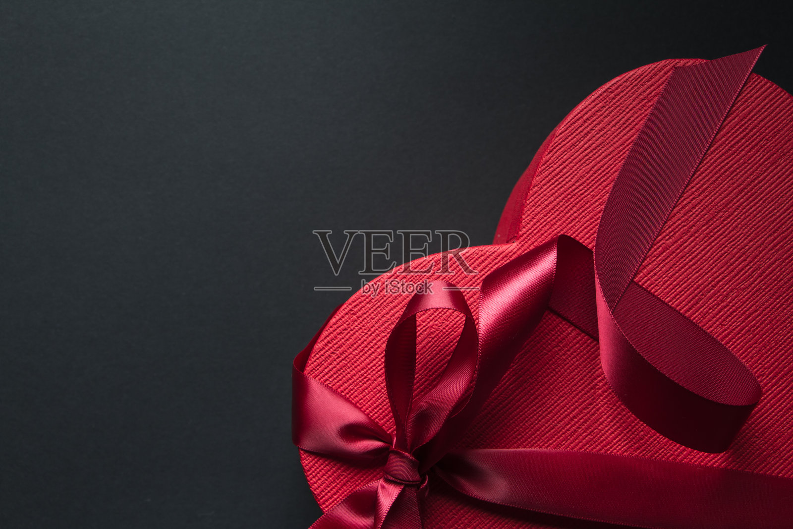 红色心形礼盒，以黑色为背景，红色丝带，礼品理念照片摄影图片