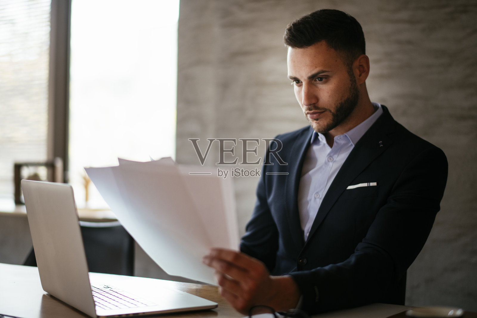 办公室里穿着蓝色西装的帅气商人。照片摄影图片