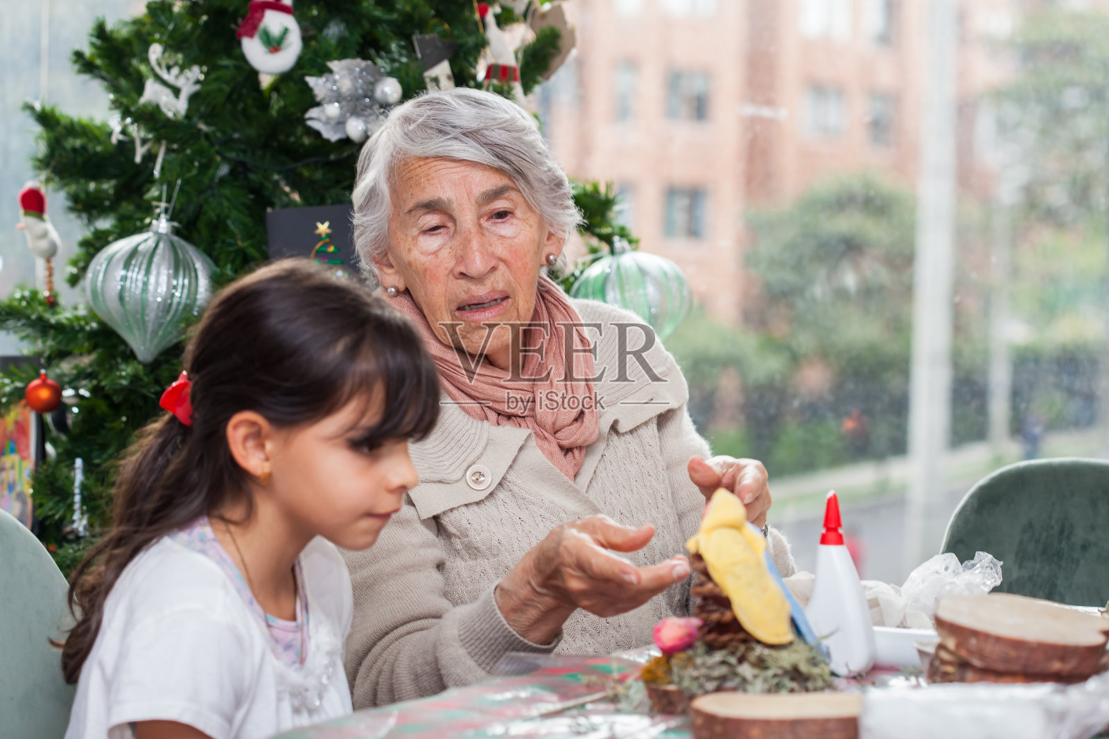 祖母教孙女制作圣诞节耶稣诞生场景手工艺品照片摄影图片