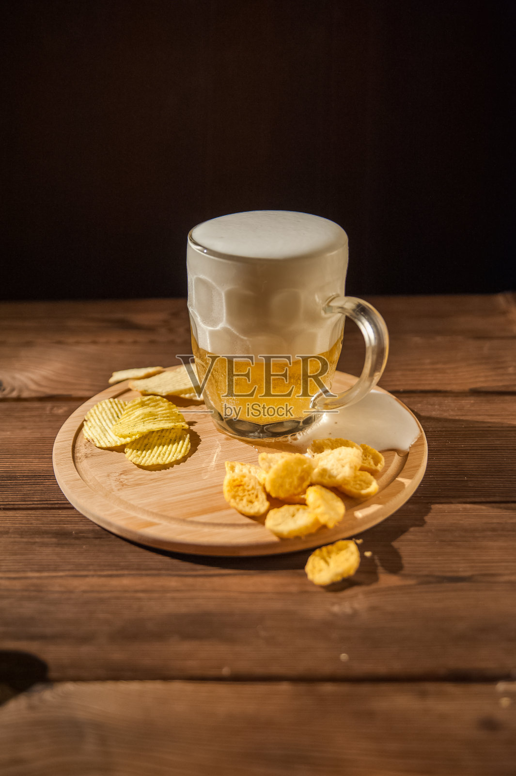 啤酒杯与啤酒和热熏鱼特写。啤酒杯，啤酒和鱼在黑暗的背景和复制空间。照片摄影图片