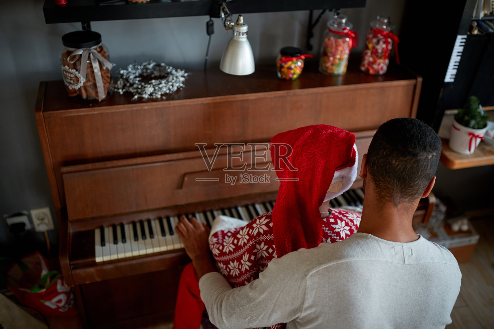 非裔美国人在圣诞节的早晨弹奏钢琴。照片摄影图片